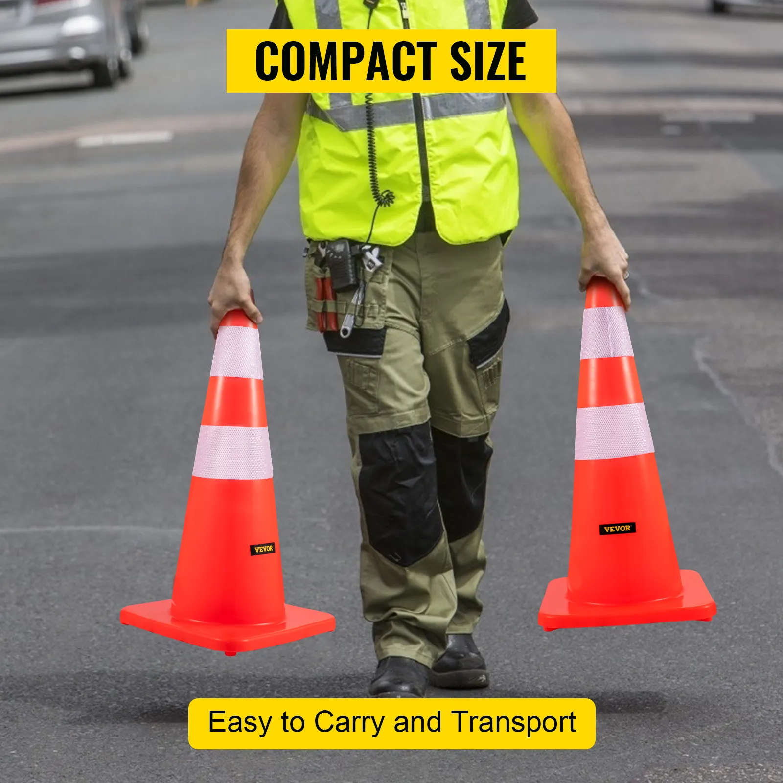 worker carrying two VEVOR safety cones on a road, demonstrating compact size.