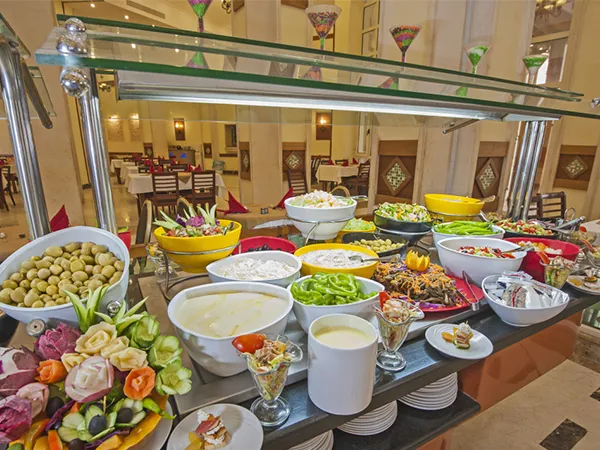 buffet table laden with assorted salads, olives, and other dishes in stylish restaurant, featuring VEVOR commercial food warmer.