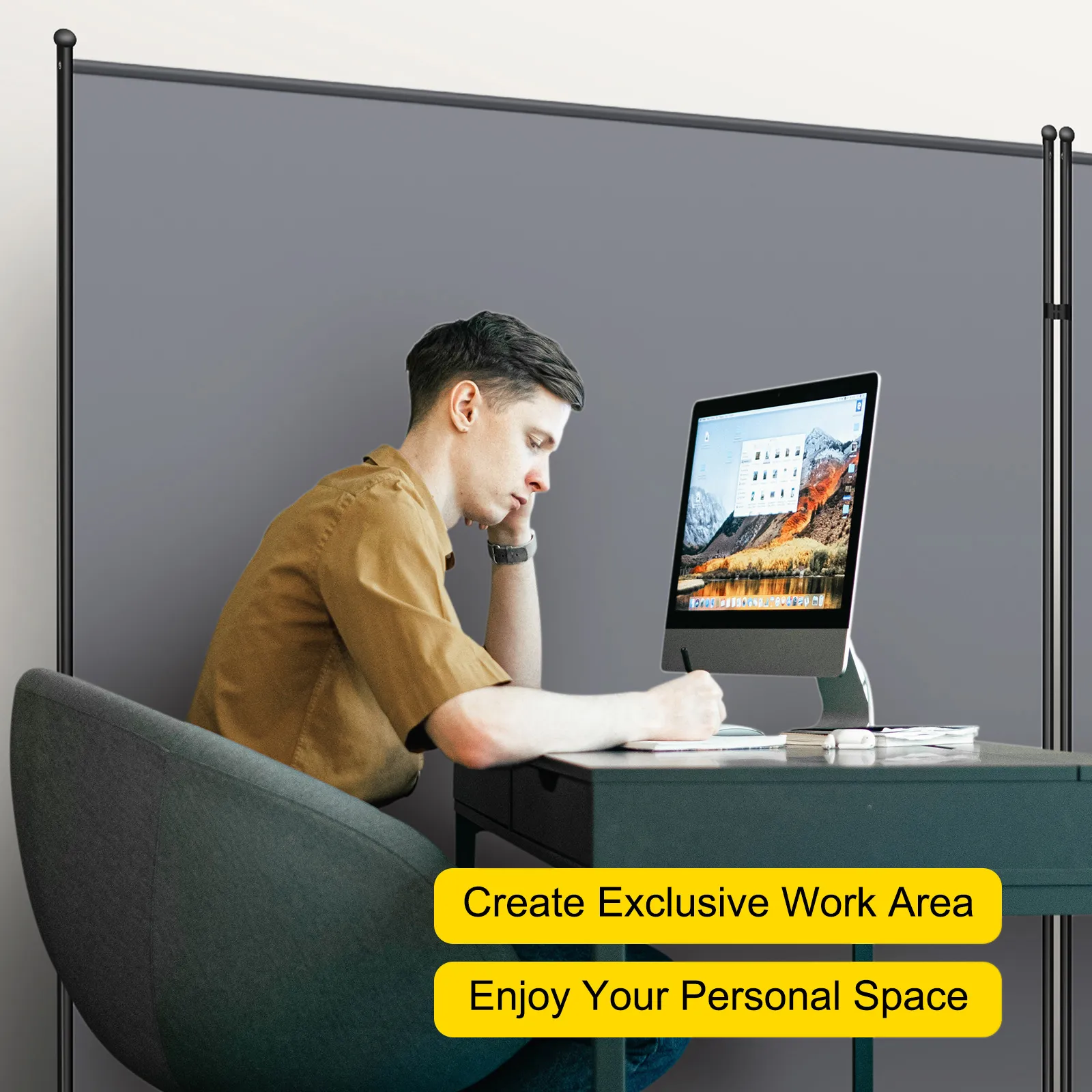 Hombre trabajando en un escritorio con una computadora, partición de oficina VEVOR en el fondo.