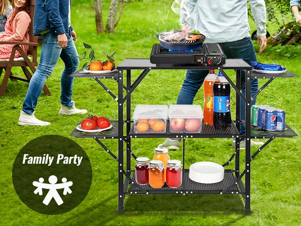 Reunión familiar con mesa de cocina para acampar VEVOR, parrilla para barbacoa y estantes organizados en el césped.