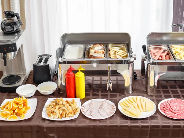 VEVOR commercial food warmer setup with various dishes, coffee maker, and condiments on a brown tablecloth.