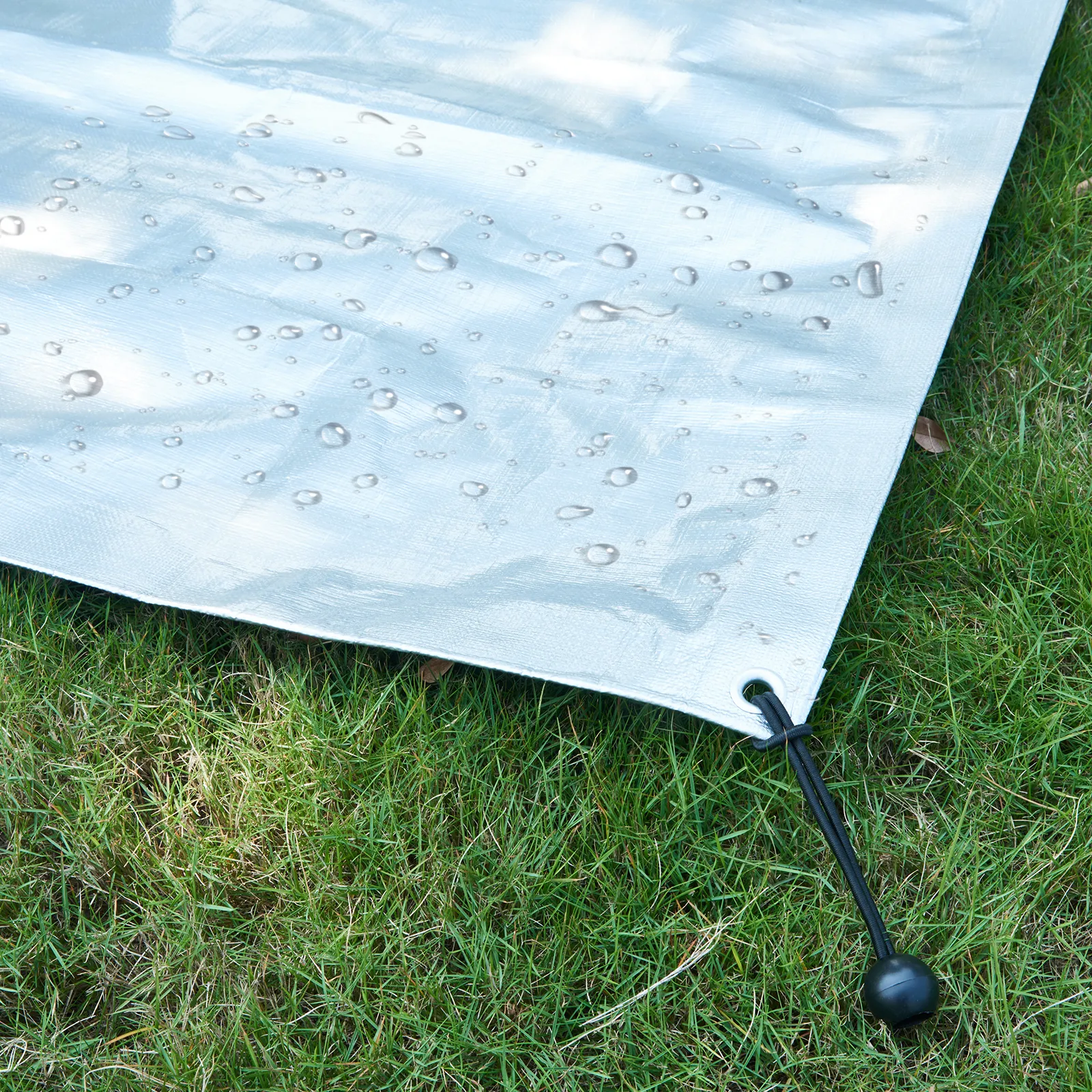 waterproof tarp with raindrops and elastic tie-down on green grass, suitable for VEVOR chicken coop.