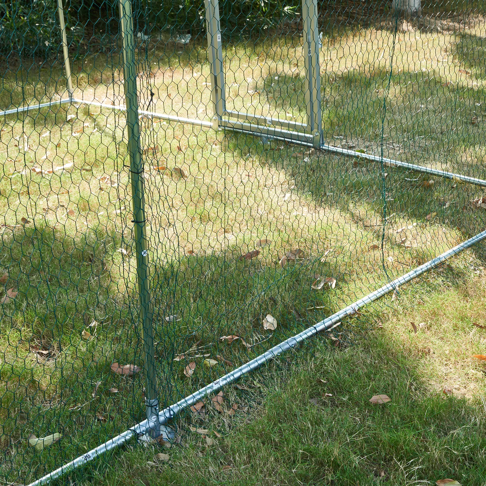 VEVOR chicken coop metal frame and mesh wire on green grass.