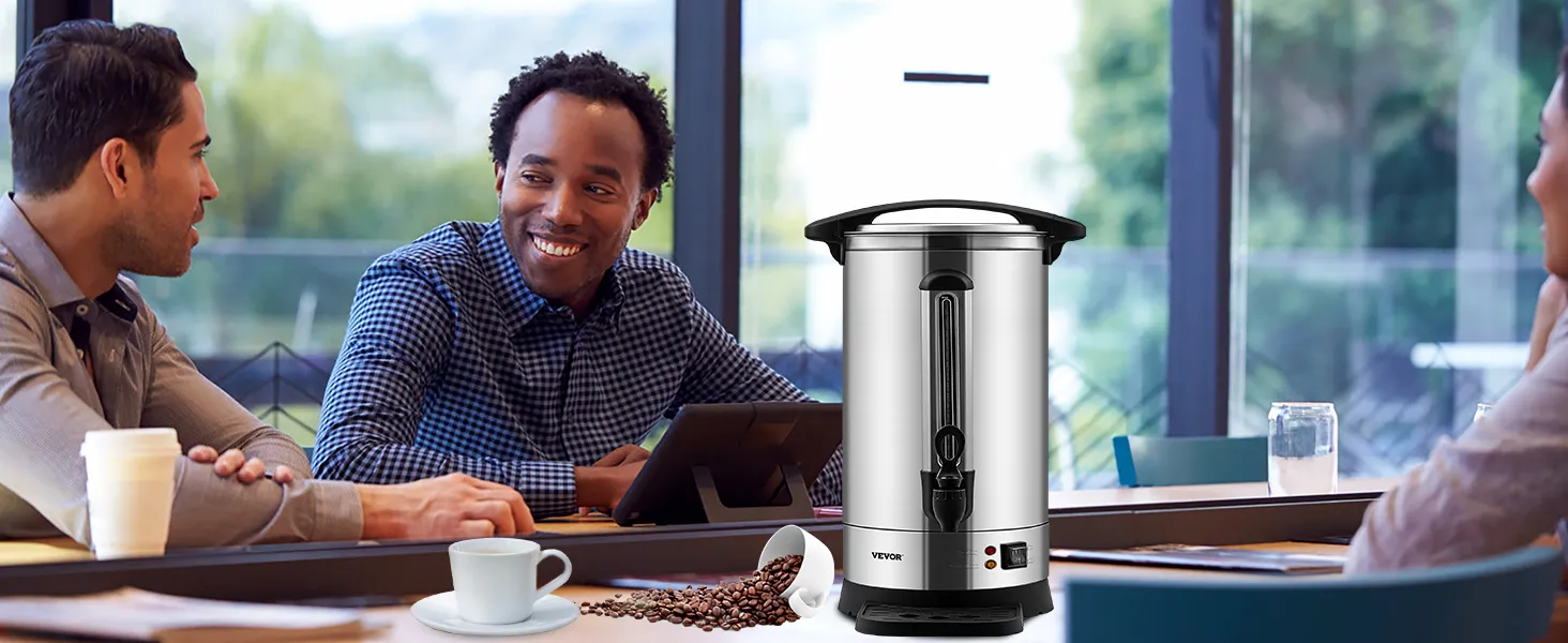 Cafetera VEVOR sobre una mesa de reuniones con gente, una taza de café y granos de café derramados cerca.