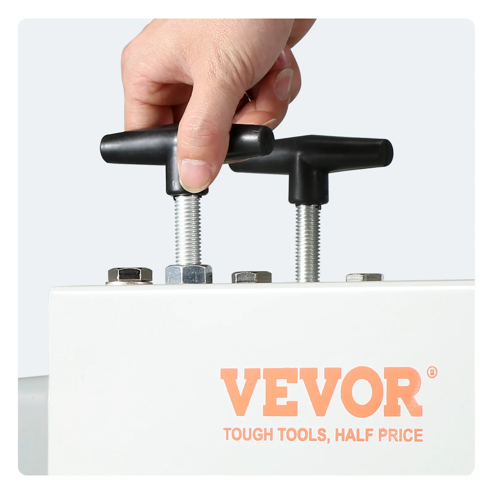 hand adjusting bolts on a VEVOR wire stripping machine with company logo and slogan visible.