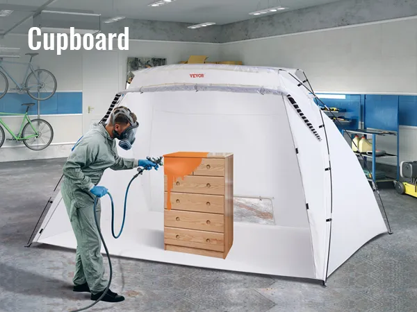 person using VEVOR portable paint booth to spray paint a wooden cupboard in a clean, organized garage.