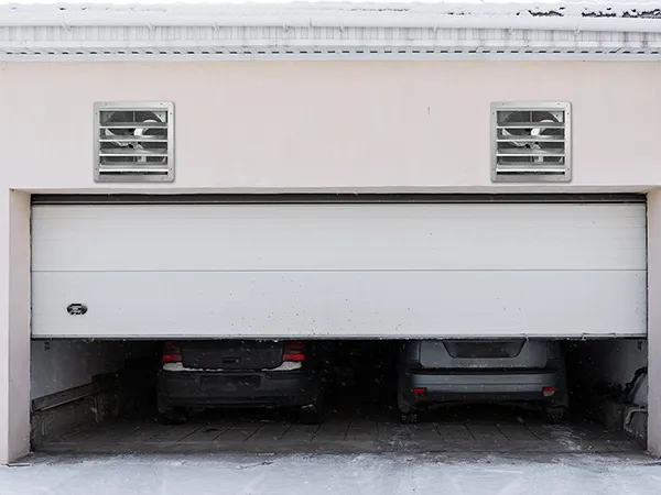 garage with two cars and two VEVOR shutter exhaust fans installed on the upper wall.