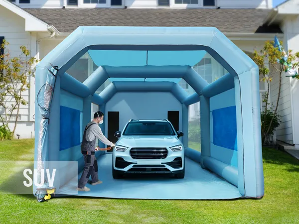 Cabina de pintura inflable VEVOR con todoterreno en el interior, situada en un patio residencial, persona preparándose para trabajar.
