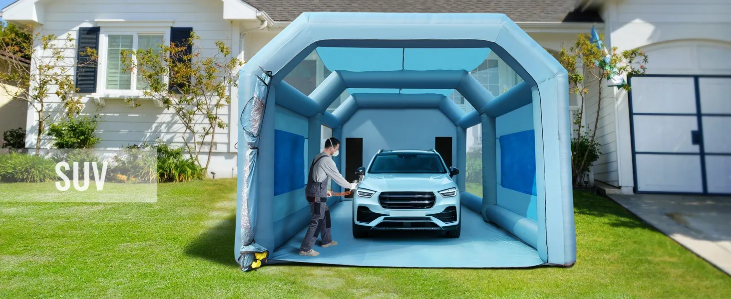 Cabina de pintura inflable VEVOR con todoterreno en el interior, situada en un patio residencial, persona preparándose para trabajar.