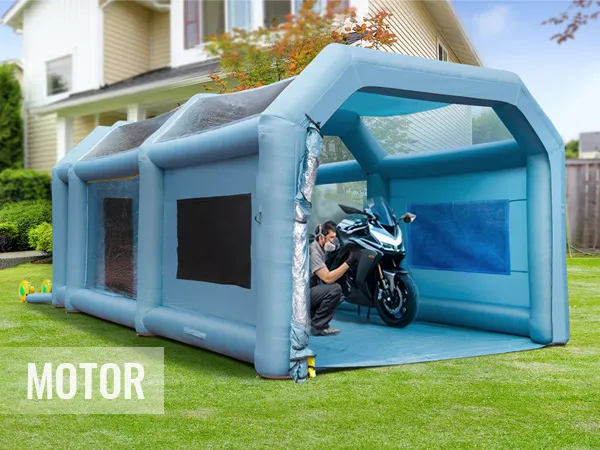 Cabina de pintura inflable VEVOR instalada en un patio trasero, que alberga una motocicleta para pintar.