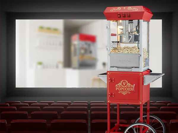 Máquina para hacer palomitas de maíz VEVOR de color rojo sobre ruedas en un teatro vacío con asientos rojos y una pantalla de fondo.