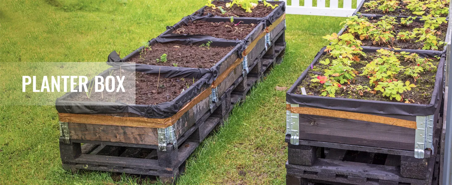 raised planter boxes on grass, partially filled with soil and seedlings. text overlay: "planter box".
