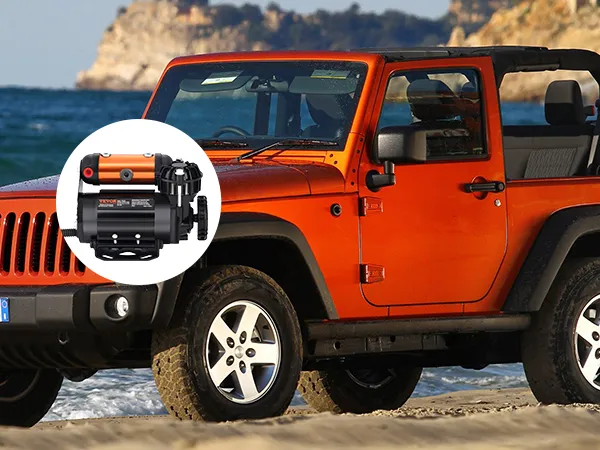 jeep arancione sulla spiaggia con kit compressore d'aria di bordo VEVOR; montagne e oceano sullo sfondo