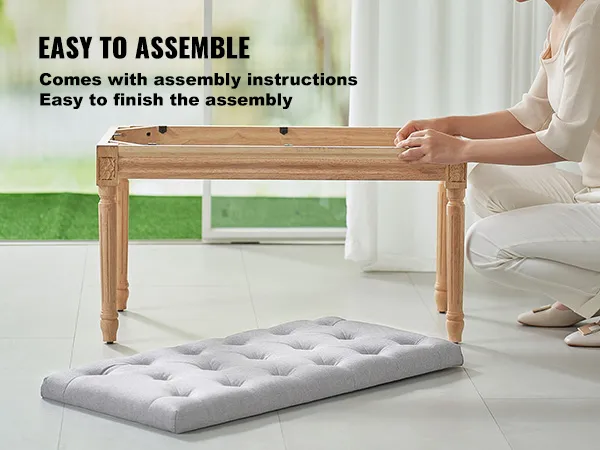 person assembling VEVOR upholstered bench with wooden legs and a gray cushion on a tile floor.