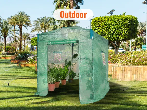 VEVOR pop up greenhouse on a sunny lawn surrounded by palm trees and vibrant garden flowers.
