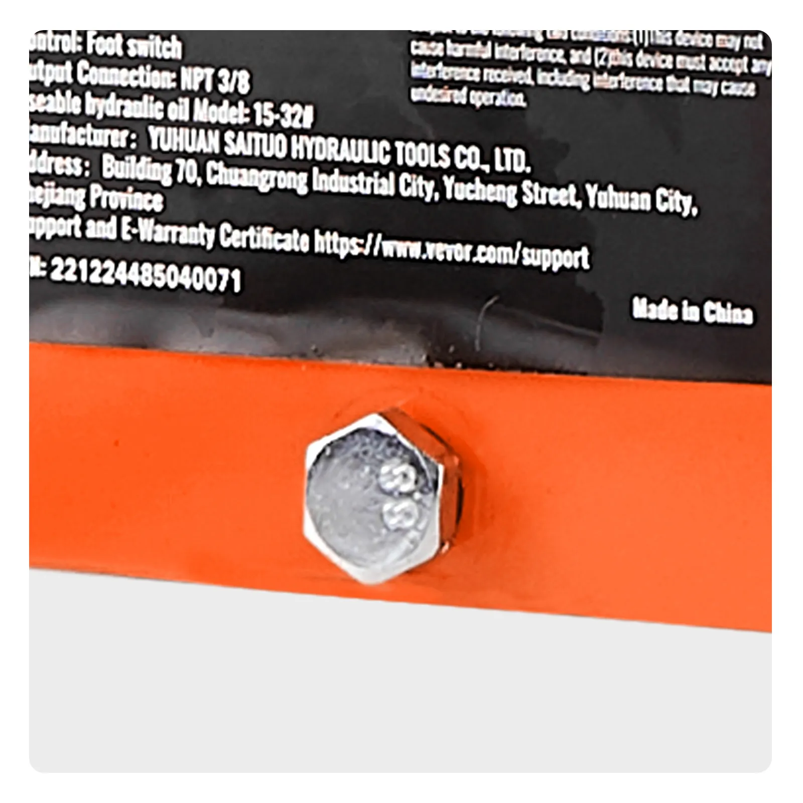 bolt on the orange base of a VEVOR electric hydraulic pump with a black label visible in the background.