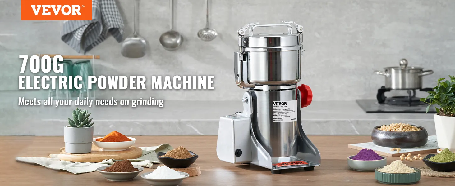 Molinillo de granos eléctrico VEVOR en la encimera de la cocina con diversas especias molidas y utensilios de cocina.