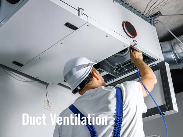 worker in hard hat adjusting hvac duct ventilation system on ceiling.
