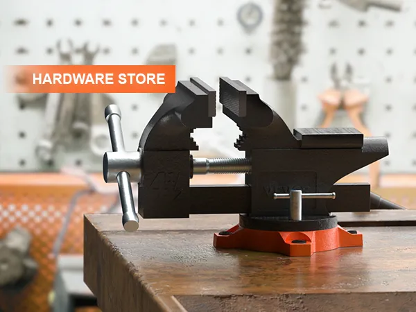 VEVOR bench vise on a workbench in a hardware store with tools on a pegboard background.