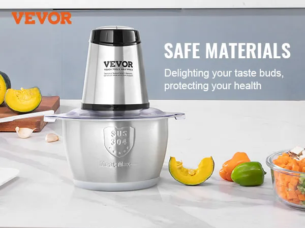Picadora de carne eléctrica VEVOR en acero inoxidable con verduras frescas sobre la encimera de la cocina.