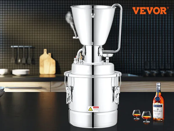 Destilador de alcohol VEVOR en la encimera de la cocina con botella y vasos, protector contra salpicaduras negro y utensilios.