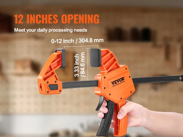 VEVOR bar clamps with 12-inch opening held by a hand in a workshop background.