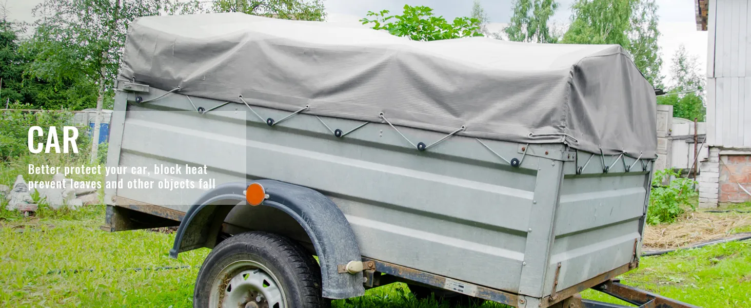 trailer with gray VEVOR waterproof tarp in a grassy area, protecting against weather elements.