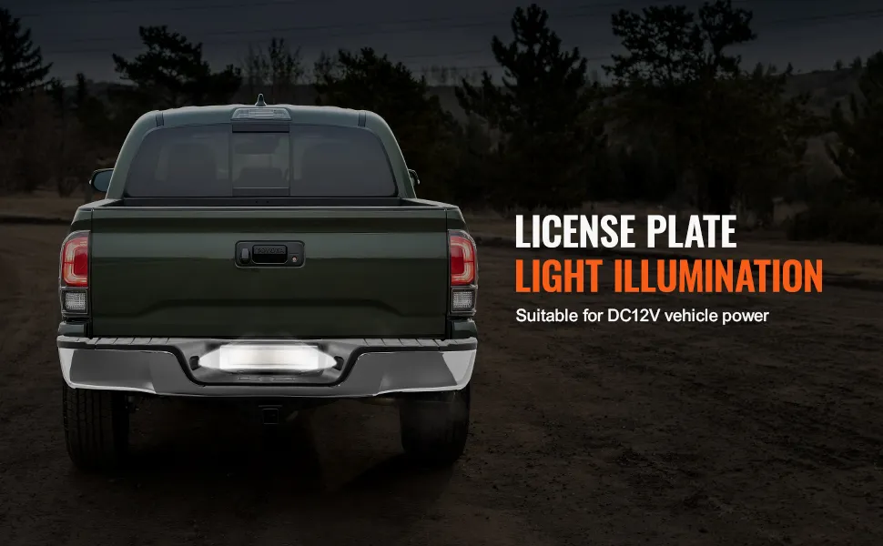 green truck with VEVOR tundra rear bumper on a dirt road, displaying license plate light illumination.