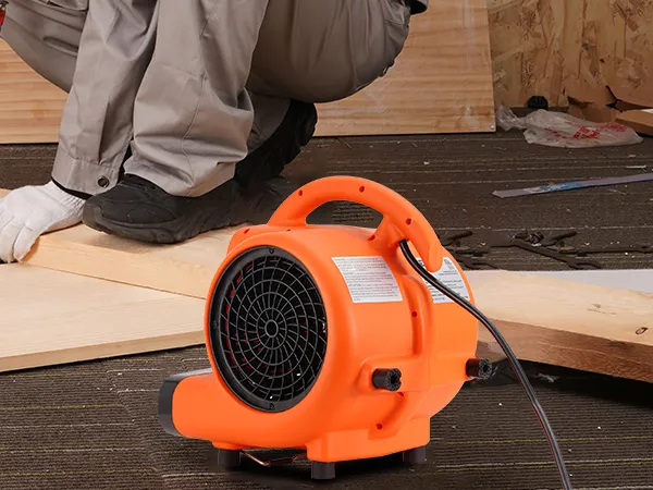 Soplador de suelo VEVOR naranja junto a un trabajador cortando madera en un taller.