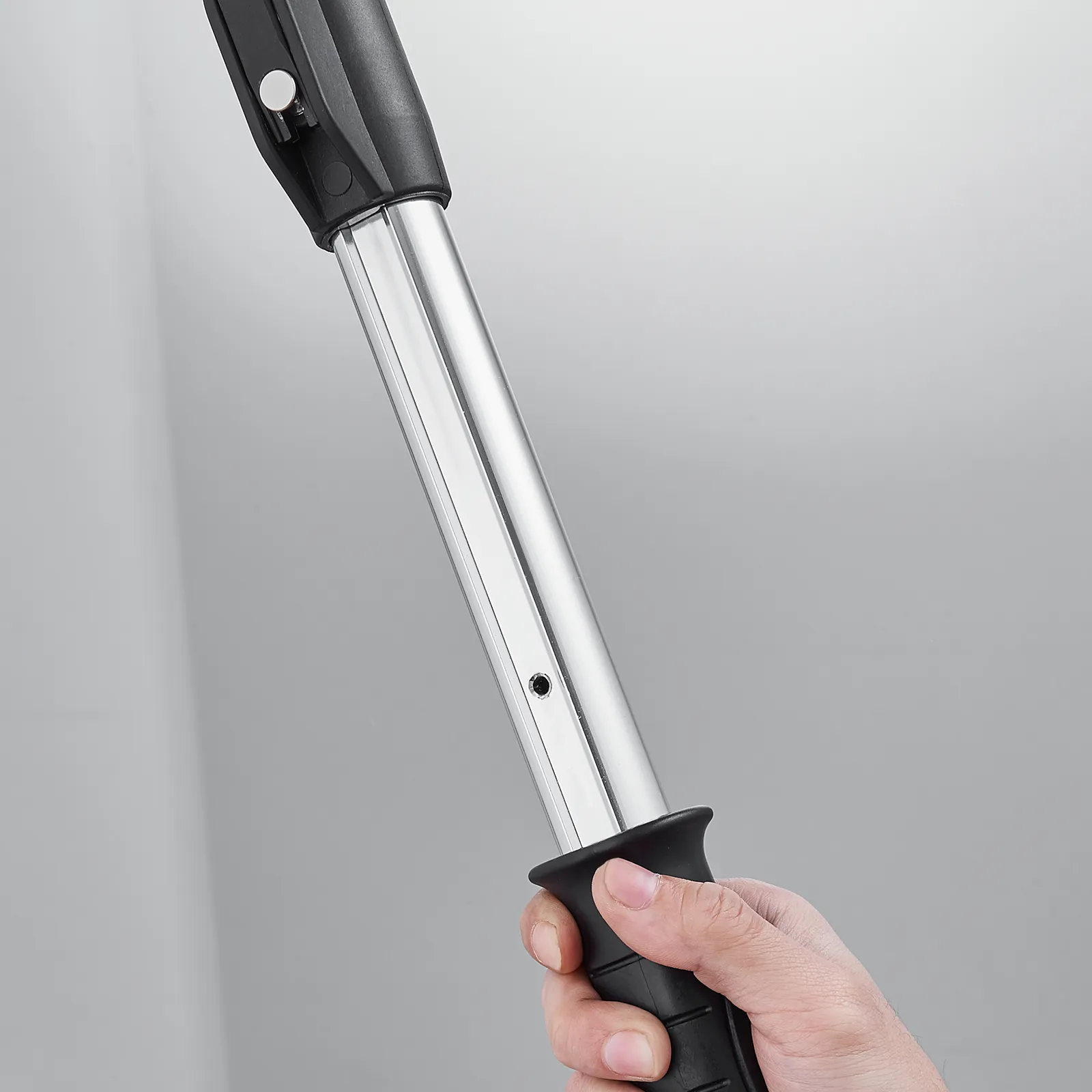 person holding VEVOR drywall flat box handle with silver shaft and black grip.
