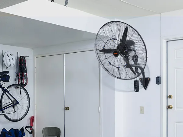 garage with VEVOR wall-mount misting fan, bike, helmet, and tools organized on the wall.
