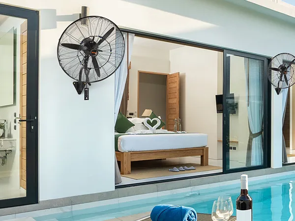 Luxusvilla mit einem an der Wand montierten Nebelventilator von VEVOR in der Nähe der Glasschiebetüren am Pool.