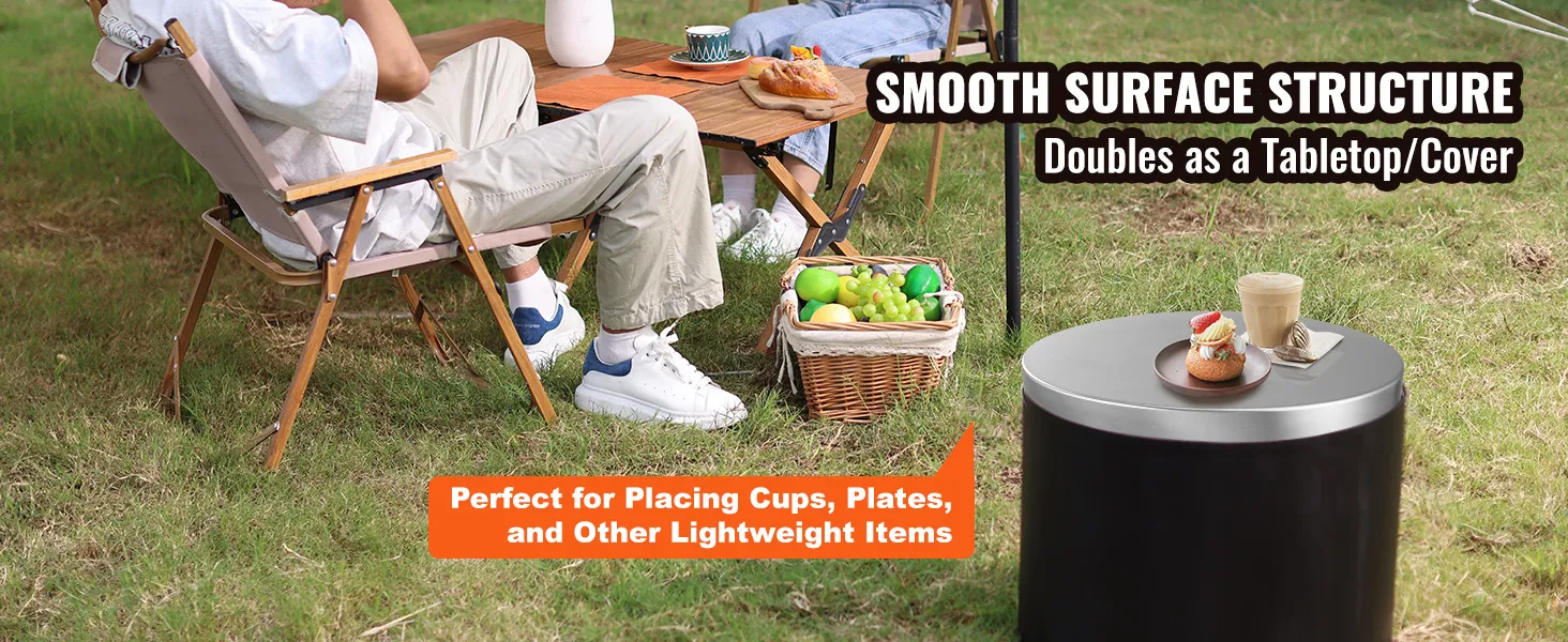 Leute, die mit Tassen und Tellern im Freien auf einer VEVOR-Feuerstellenabdeckung sitzen, umgeben von Gras.