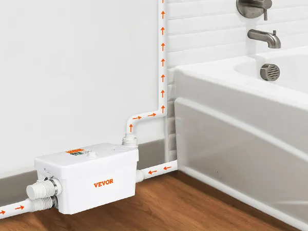 VEVOR macerator pump installed beside a white bathtub with arrows showing water flow direction.
