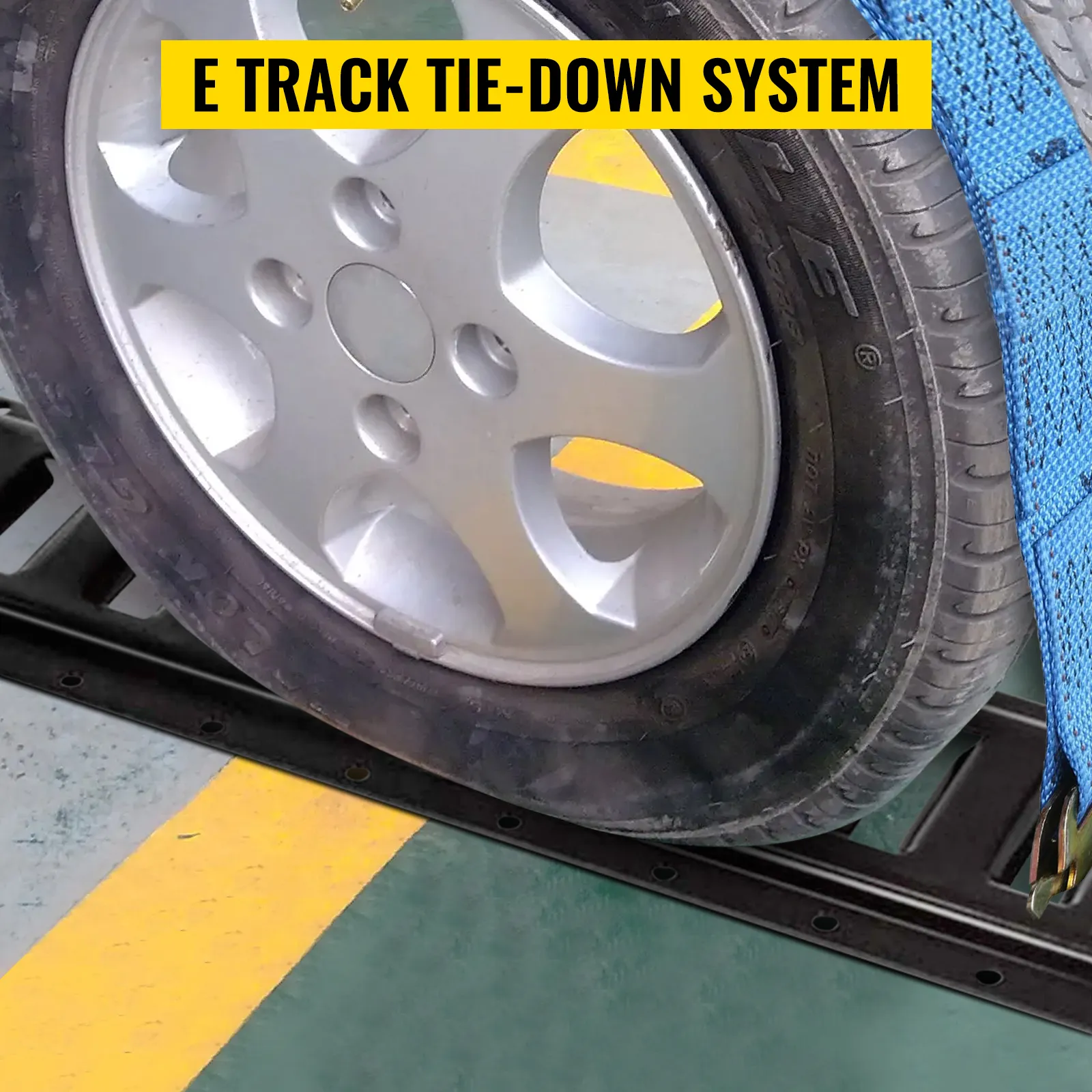 tire secured with VEVOR e-track tie-down rail and blue strap on industrial floor.