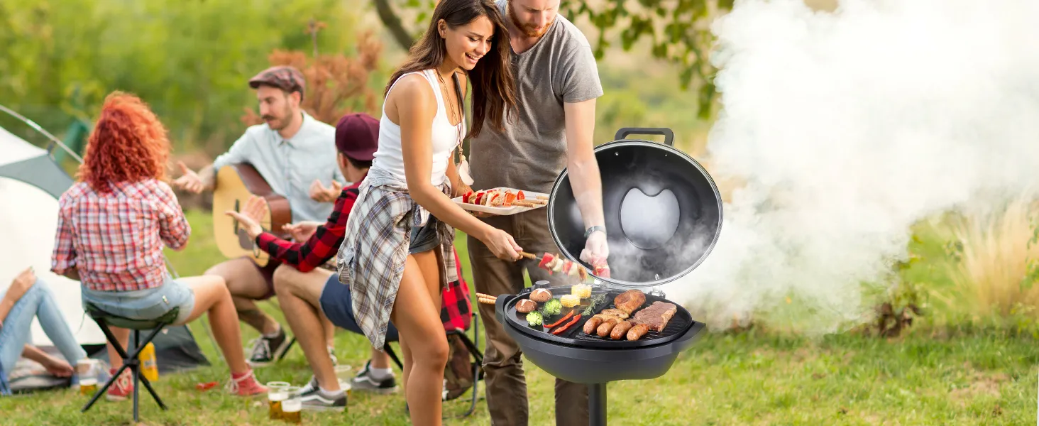 Grupo disfrutando de una barbacoa con parrilla eléctrica VEVOR al aire libre, cocinando carnes y verduras variadas.