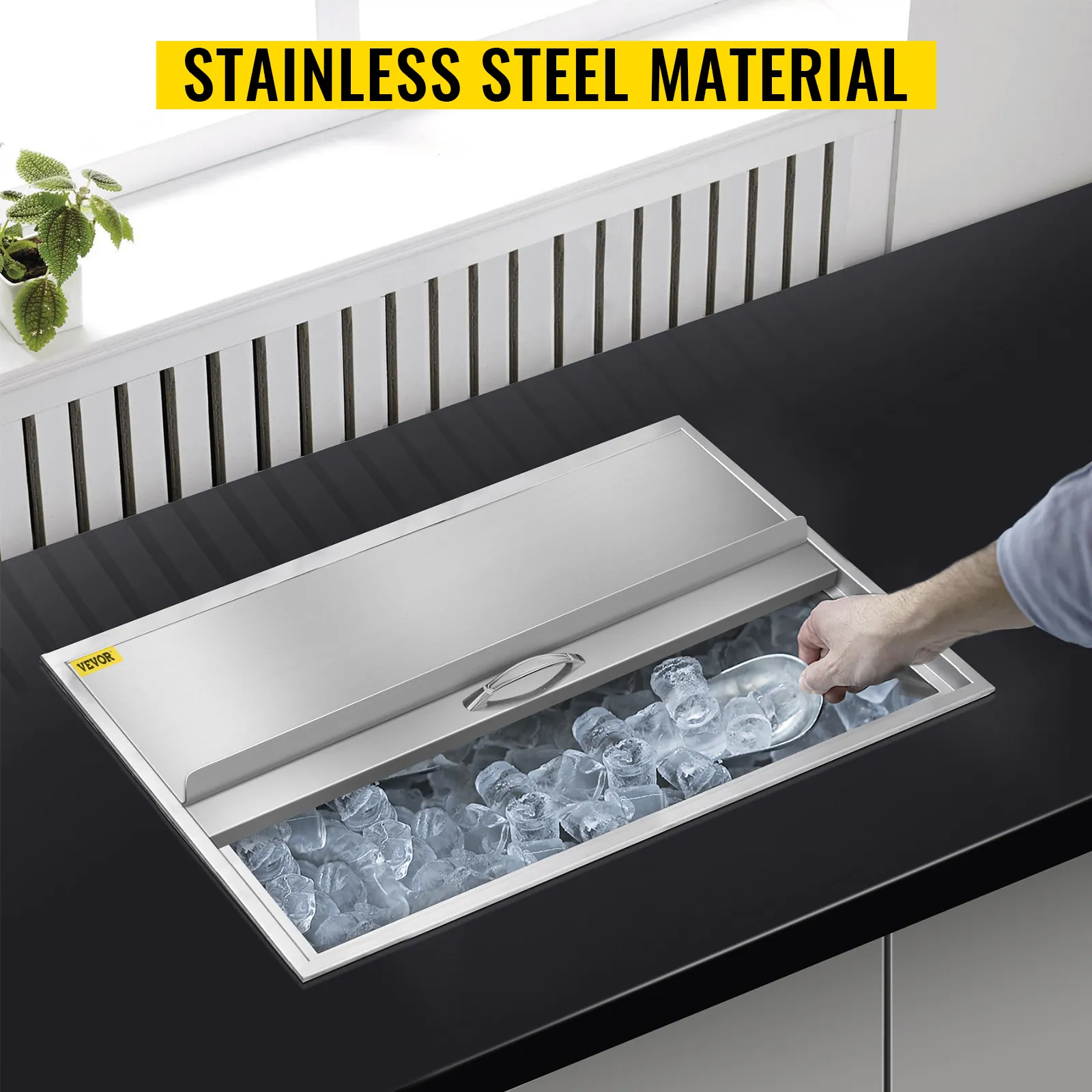 Persona usando una pala para hielo en una hielera de acero inoxidable VEVOR sobre una encimera.