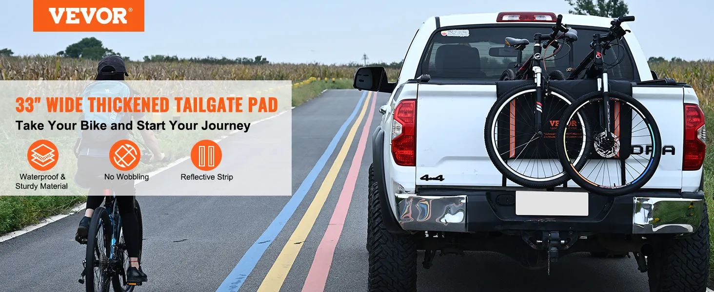 white pickup truck with VEVOR tailgate pad carrying two bikes on a country road with a cyclist.