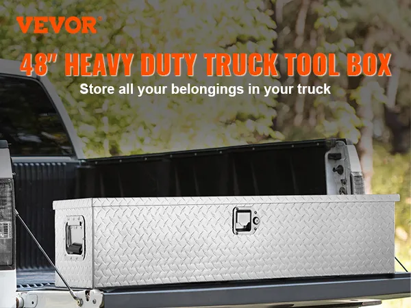 VEVOR truck bed tool box on an open truck tailgate with trees in the background.