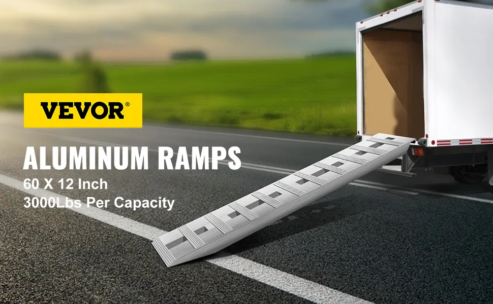 VEVOR aluminum trailer ramps attached to a truck on a road.
