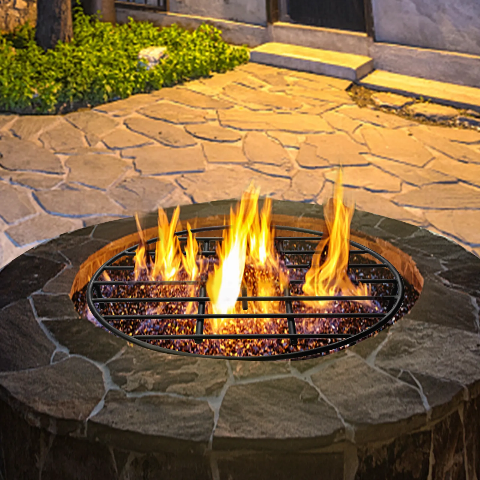 VEVOR fire pit grate with vibrant flames on a stone patio at dusk.