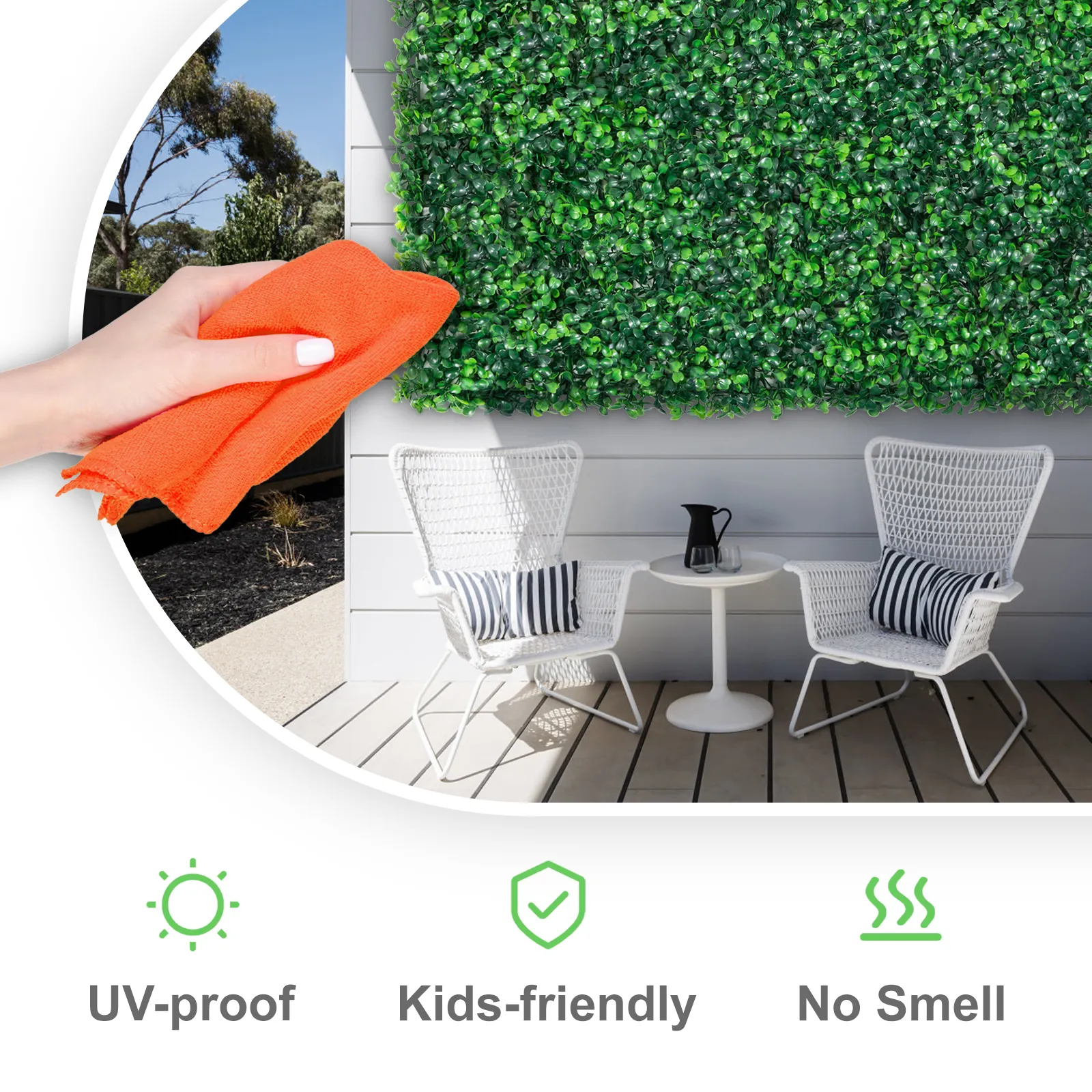 hand holding orange cloth in front of VEVOR artificial boxwood panel on patio wall.