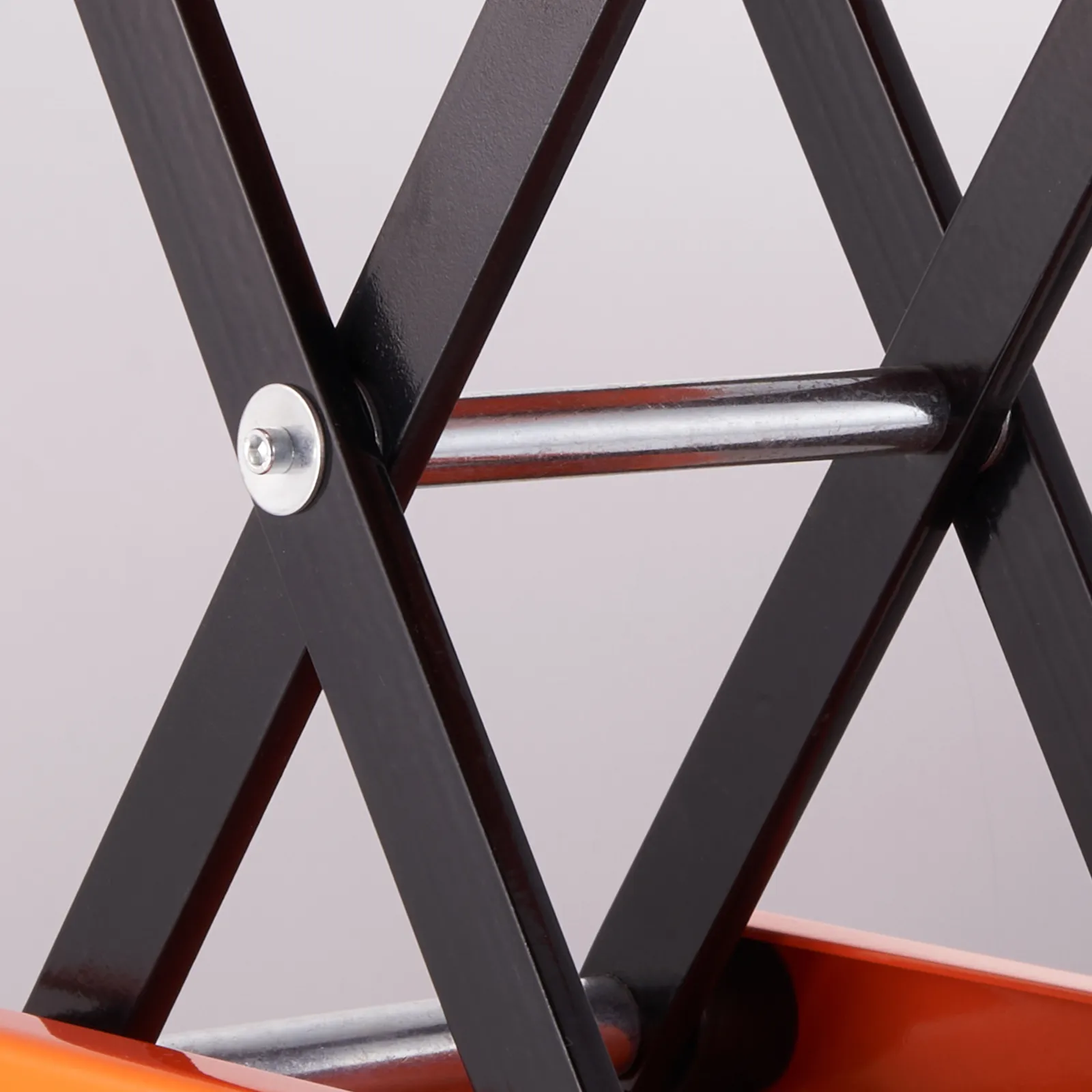 VEVOR motorcycle lift close-up showing black metal arms and an orange base.