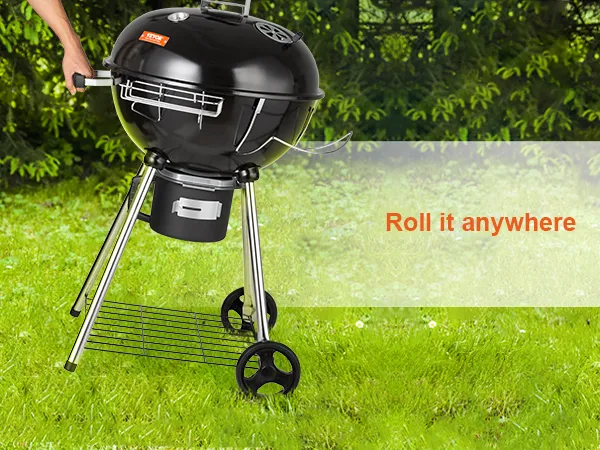 Parrilla de carbón portátil VEVOR con ruedas sobre césped verde, perfecta para asar al aire libre.