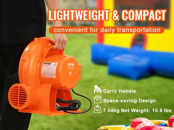 VEVOR bounce house blower being carried, with a colorful bounce house in the background.