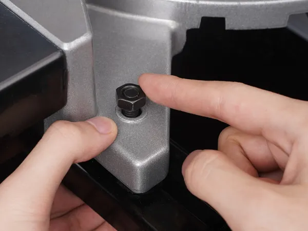 tightening the VEVOR miter saw stand bracket with a hand and screw.