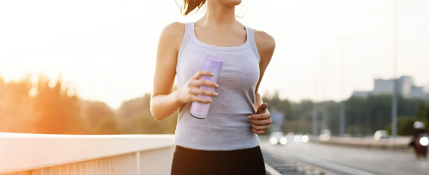 woman jogging on bridge holding a purple tumbler made with VEVOR tumbler heat press.
