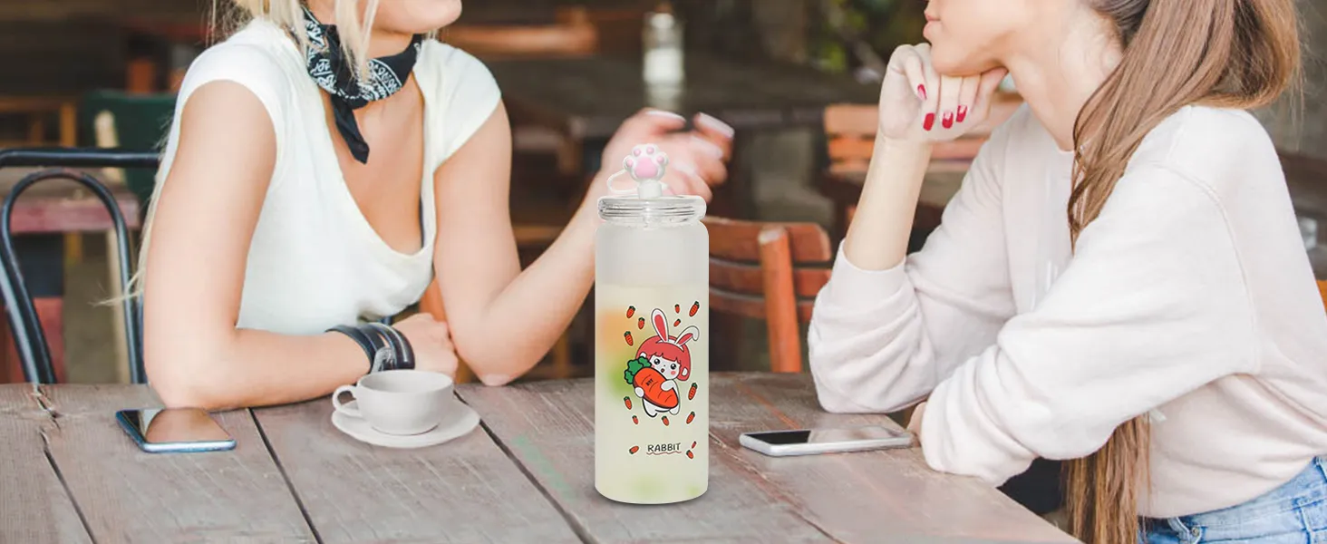 two women talking at a table with a cute rabbit-themed water bottle and smartphones.