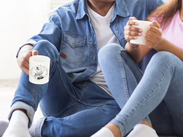 couple sitting on the floor enjoying coffee, showcasing custom mugs made with VEVOR tumbler heat press.