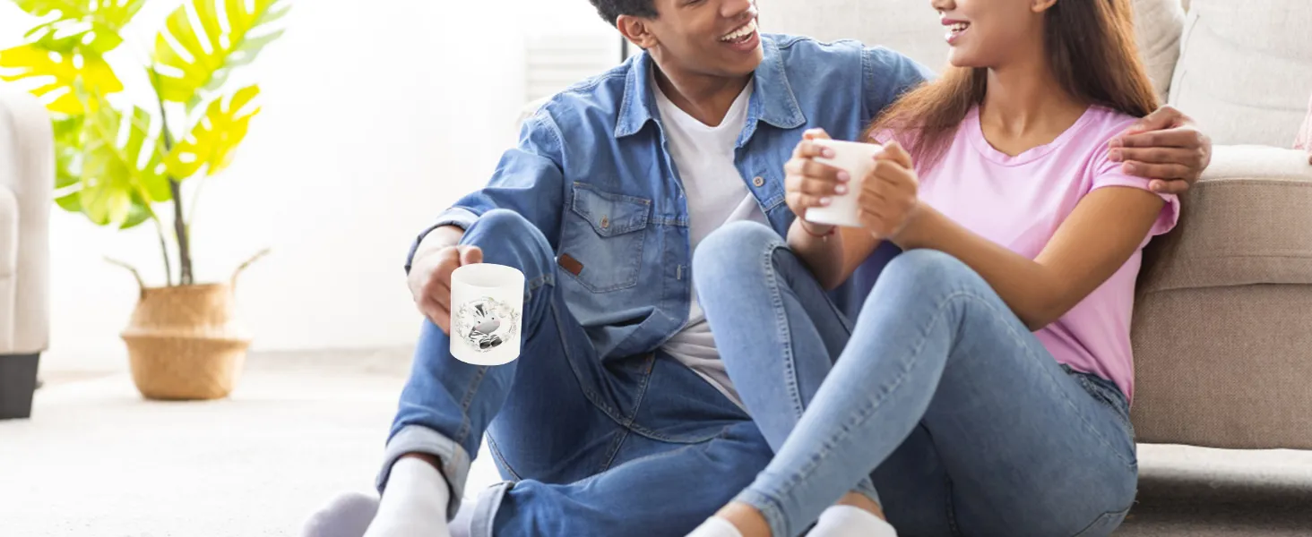 couple sitting on the floor enjoying coffee, showcasing custom mugs made with VEVOR tumbler heat press.